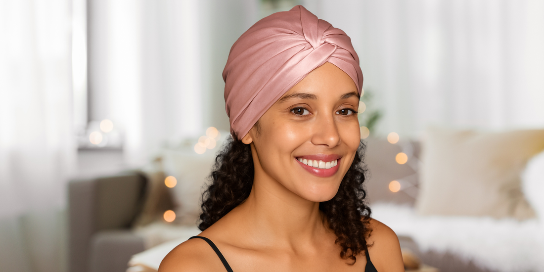 Femme en France aux cheveux bouclés portant un turban en soie rose Ade’Soie pour la nuit