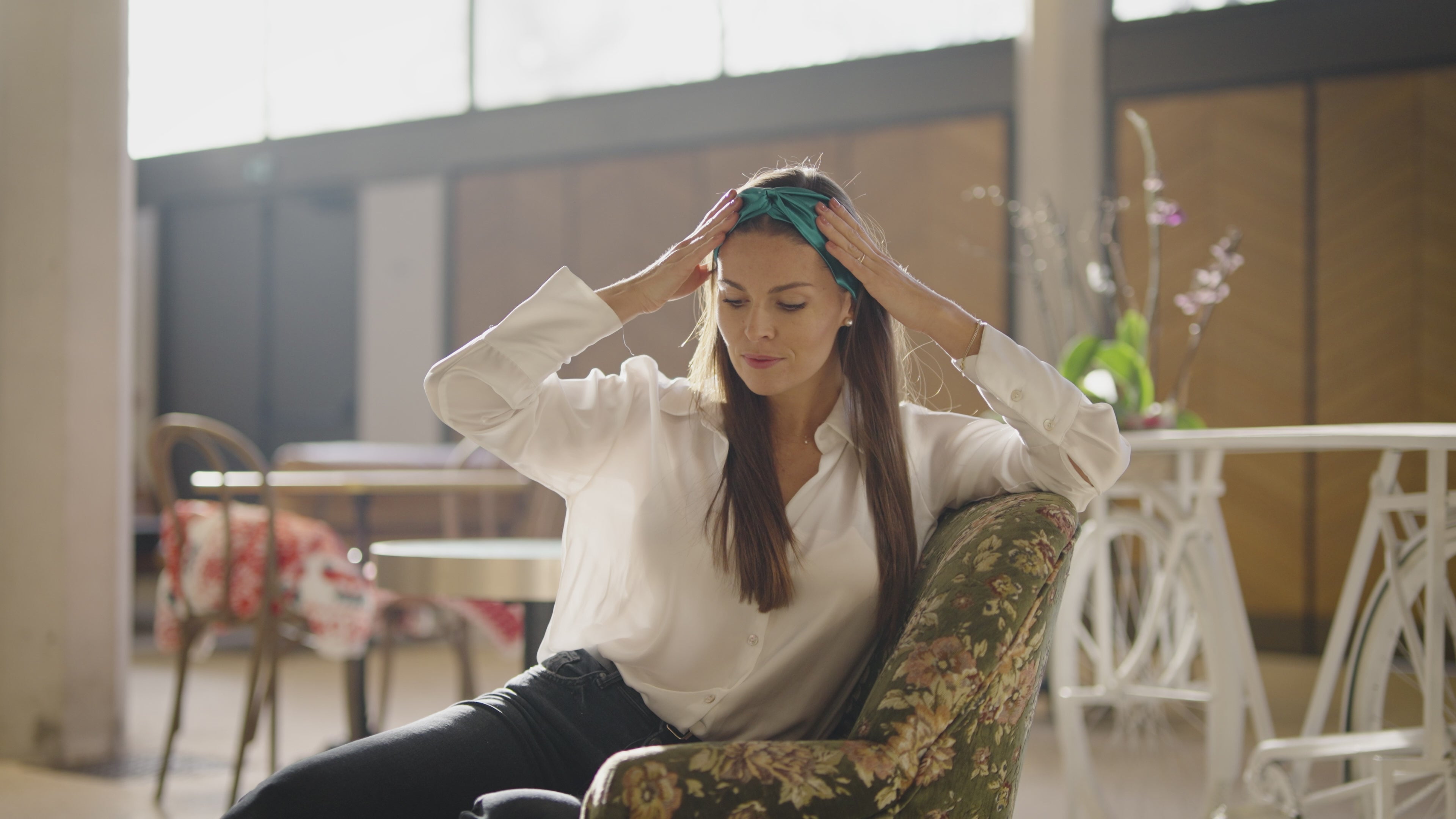 Charger la vidéo : Présentation du bandeau en soie vert uni, design en croix, élastique à l&#39;arrière. Il est porté par un modèle féminin.